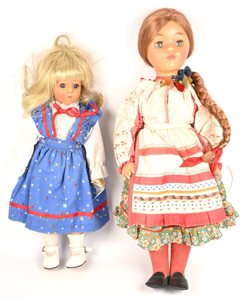 Twee poppen van kunststof. Eentje met slaapogen en traditionele klederdracht.