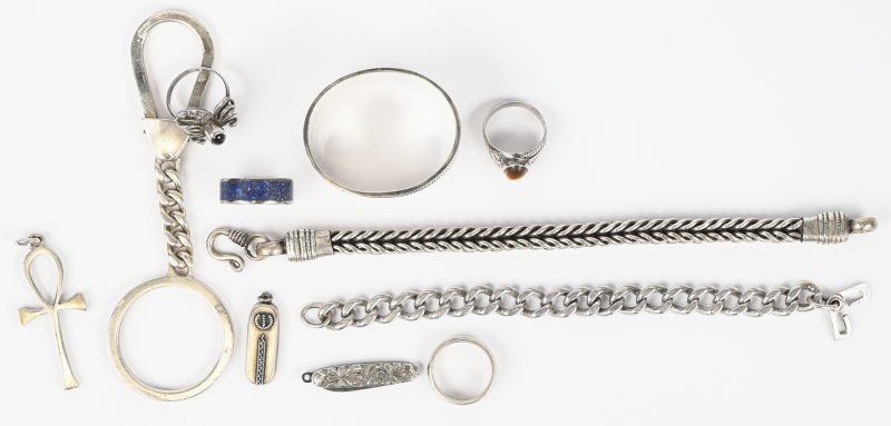 Een lot zilveren voorwerpen bestaande uit een servetring, een sleutelhanger, een mini zakmesje, 2 hangertjes, 2 armbanden en 4 ringen.