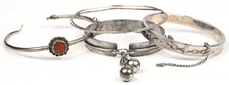 Vier verschillende zilveren slavenarmbanden waarvan 1 bezet met een half edelsteen en 1 slot te herstellen.