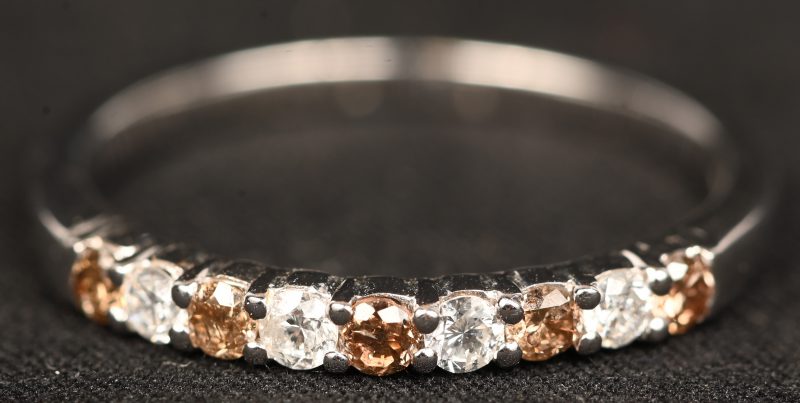 Een 18 kt witgouden ring bezet met witte en cognackleurige briljanten met een gezamenlijk gewicht van 0,38 ct.