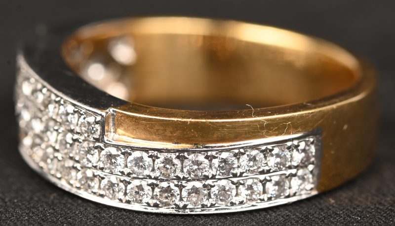 Een 18 kt wit-en geelgouden ring bezet met briljanten met een gezamenlijk gewicht van 0,62 ct.