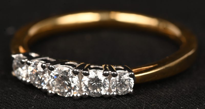 Een 18 kt wit-en geelgouden ring bezet met briljanten met een gezamenlijk gewicht van 0,52 ct.