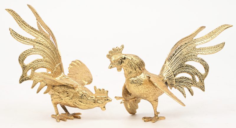 Een paar kleine vergulde metalen kemphanen als tafelversiering.