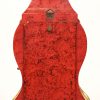 Een kleine pendule, rood en goud gelakt in de stijl van Neuchatel. Met slinger en sleutel.