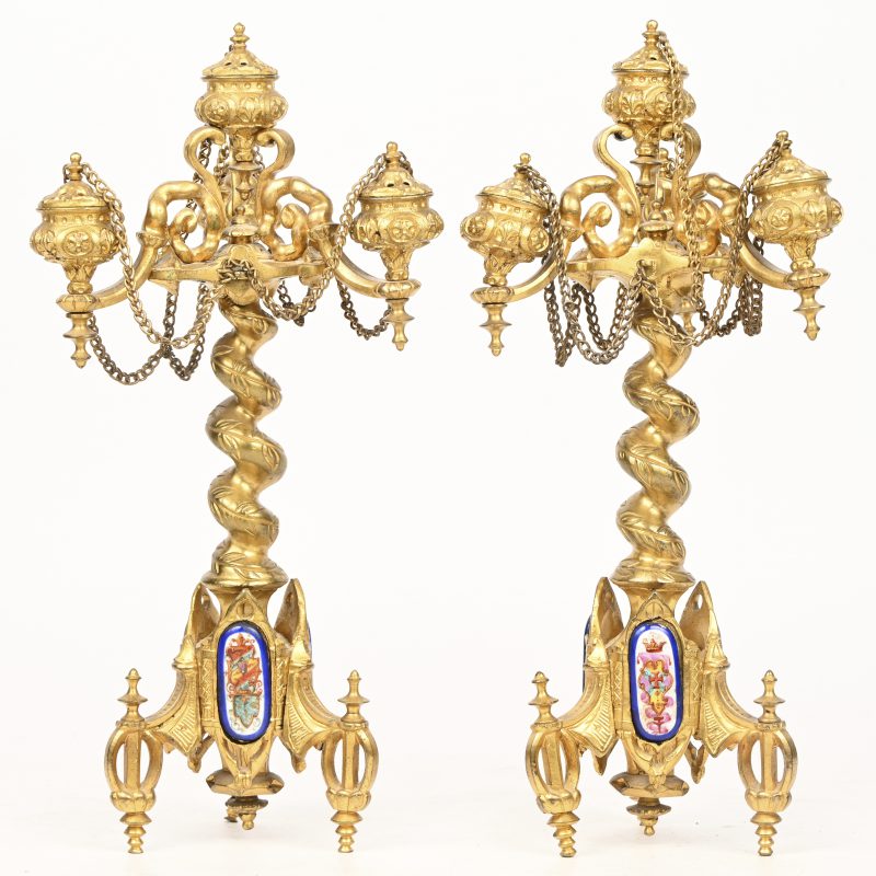 Ee paar fijne verguld bronzen kandelaars met getorste stammen en op driepoten  versierd met drie porseleinen plaquetten in de geest van Sèvres. Vier lichtpunten voorzien van enkele dekseltjes.