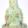 Guanyin in hurkzit, handen in Dhyana Mudra met een scroll. Chinees polychroom porselein.