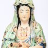 Guanyin in hurkzit, handen in Dhyana Mudra met een scroll. Chinees polychroom porselein.