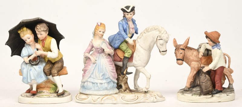Drie beeldjes van polychroom biscuit. Een jongetje met ezel, een jong koppel onder een paraplu en een elegant koppel met een paard (letsel aan een arm).