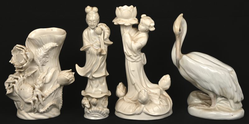 Vier stuks monochroom wit porselein, een vaasje, een kandelaar met personage, een Guanyin en een pelikaan.
