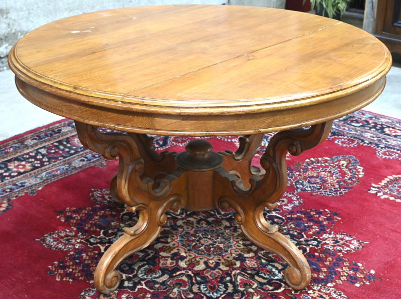Een ronde massief houten tafel, barst in het blad.