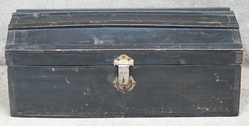 Een zwart geschilderde houten koffer.