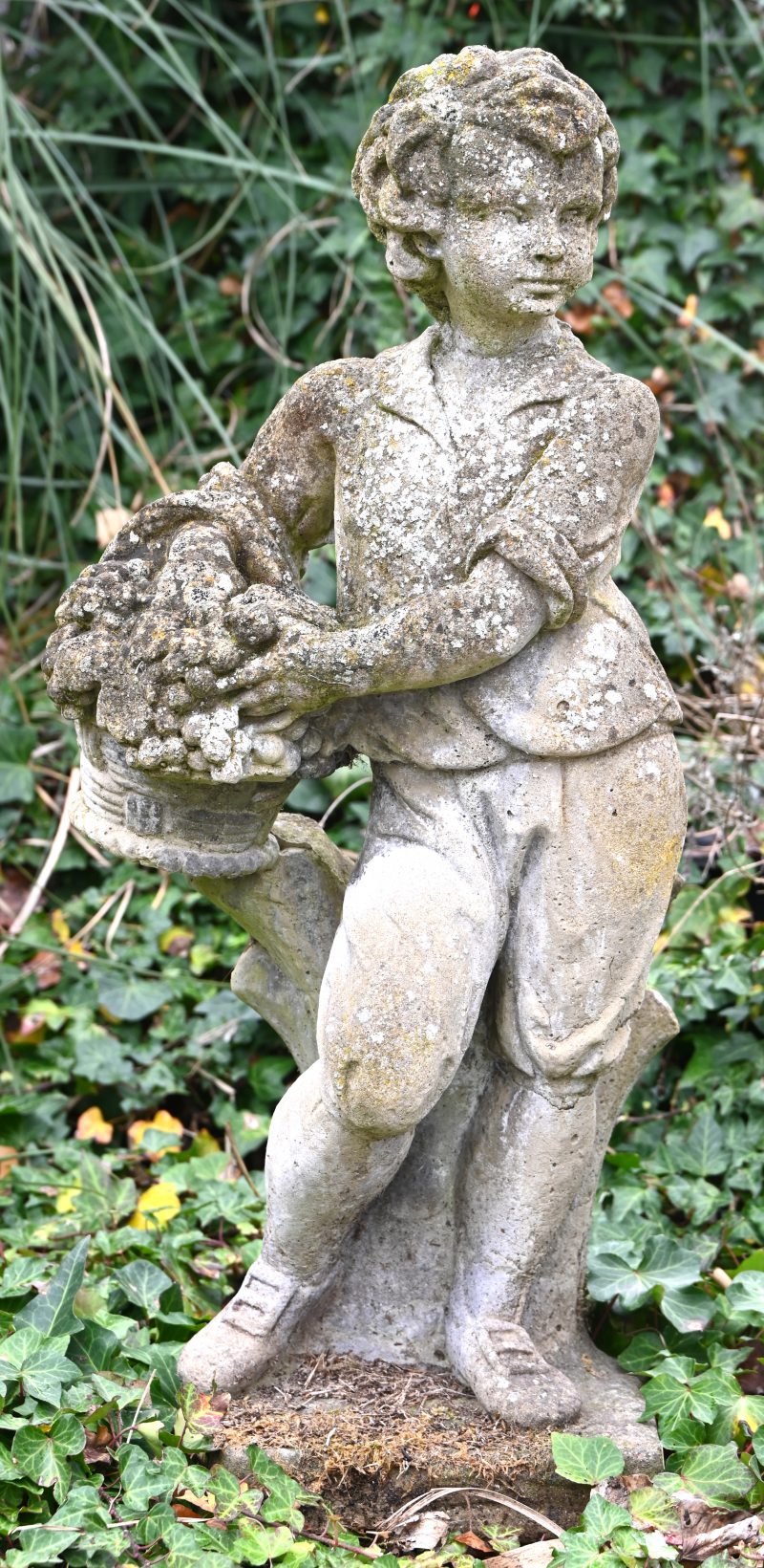 “Jongen met fruitmand”, een betonnen tuinbeeld.