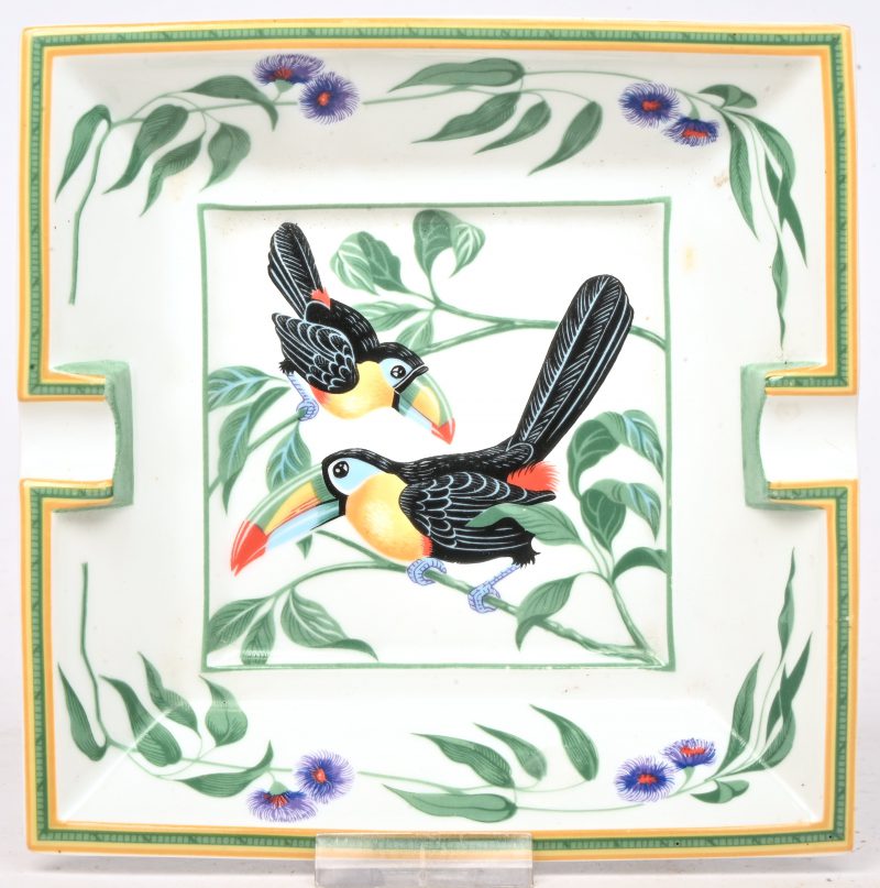 Een porseleinen asbak gedecoreerd met 2 toekans, gemerkt Hermés, made in France.