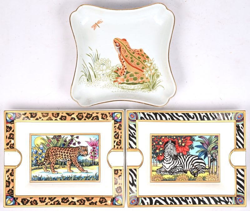 Drie porseleinen asbakken waarvan 2 uit de Safari reeks van Villeroy & Boch, Jaguar en Zebra, en een asbak gedecoreerd met een kikker gemerkt Salvatore Ferragamo.