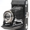 Een Zeiss Ikon Klio balgcamera met lederen etui.