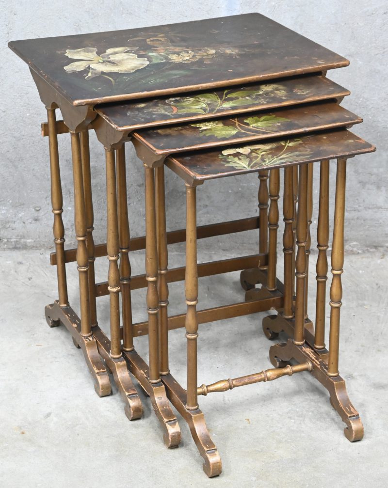 Een nest of tables. Vier goudkleurige houten tafeltjes met een decor van bloemen. Vroeg 20ste eeuw.