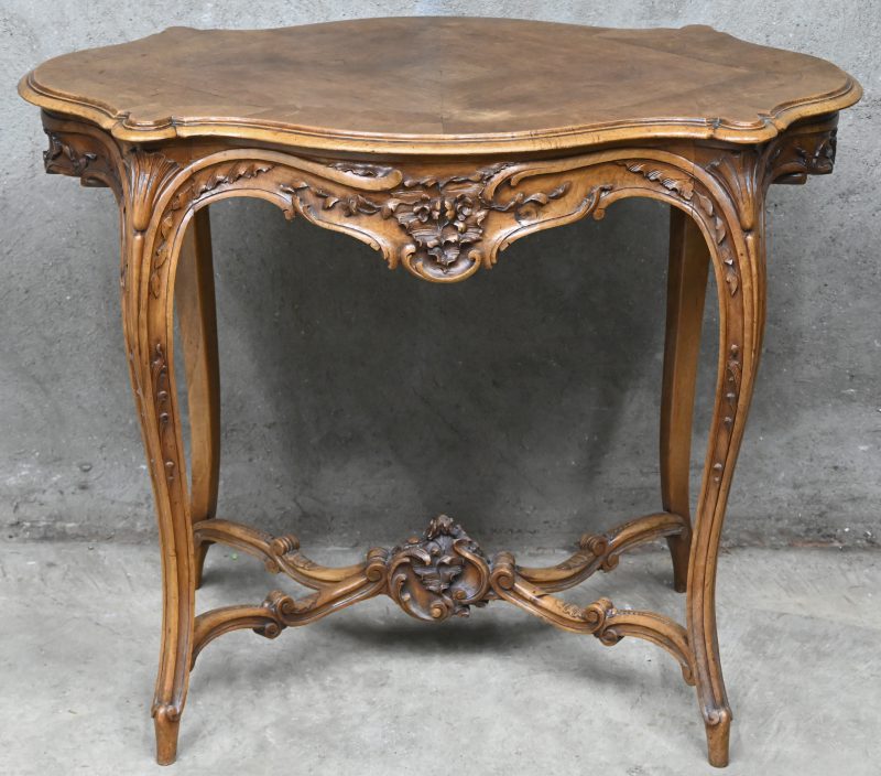 Een houten bijzettafeltje in Louis XV stijl met gesculpteerde delen.