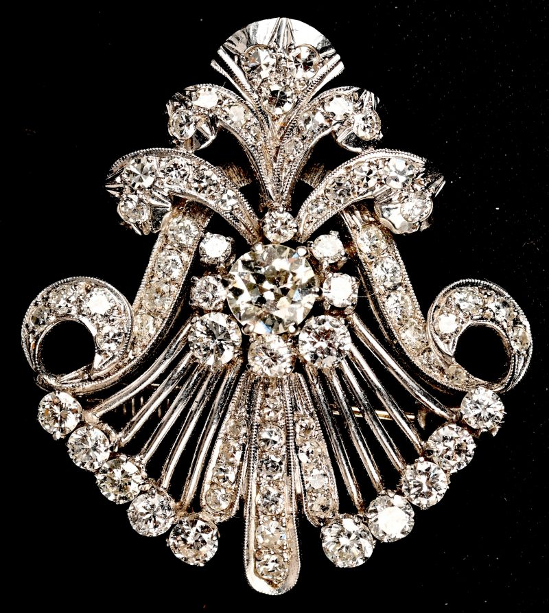 Een platina broche en of hanger bezet met een centrale diamant van +- 0,54 ct. en diamanten met een gezamenlijk gewicht van +- 1,36 ct.