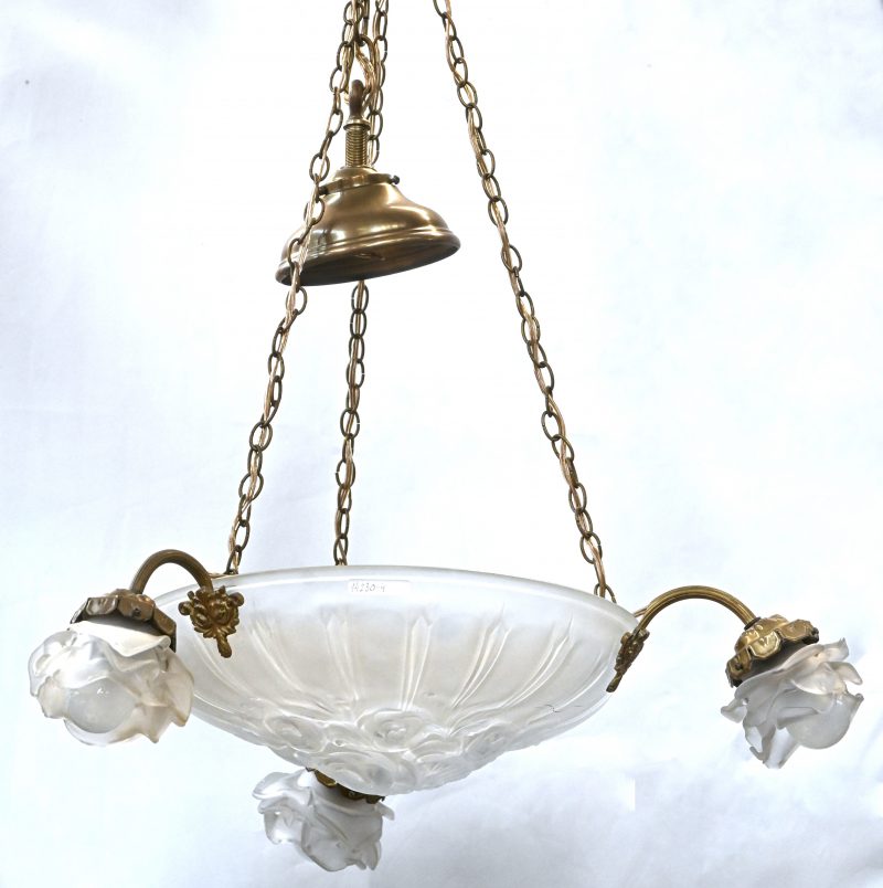 Een hanglamp met centraal een glazen coupe en drie lichtpunten.