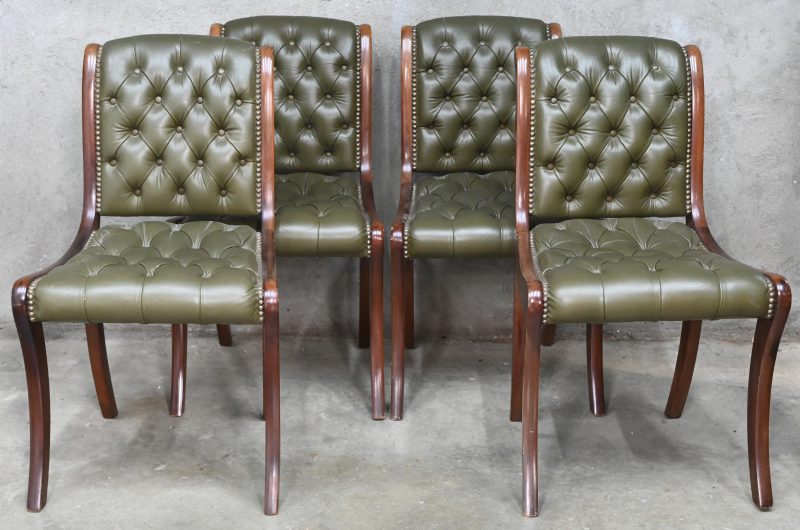 Een set van vier stoelen met gacapitoneerde, groen lederen zit en rug.