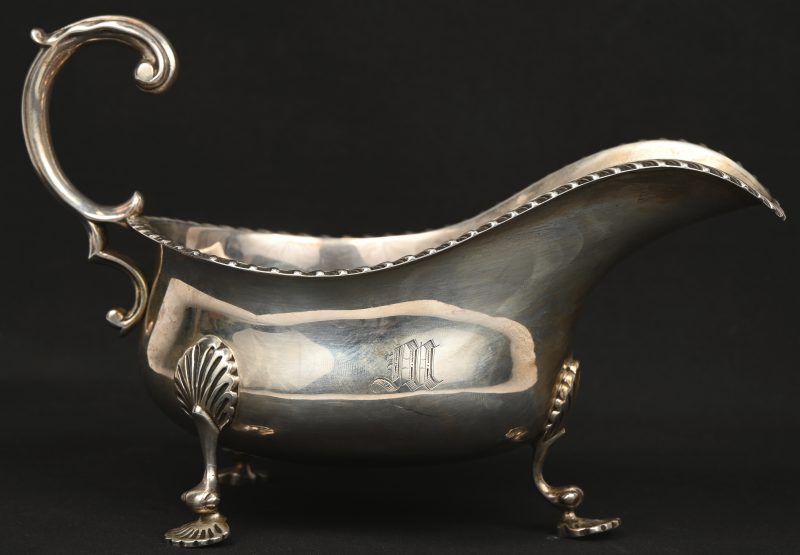 Een zilveren sauskan met Sheffield keurmerken. Jaarletter T (1911), makersmerk van Martin, Hall & Co. Met een brutogewicht van 375 gram.