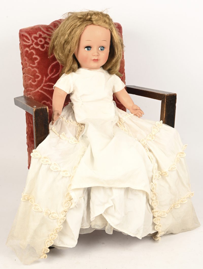 Een vintage Unica pop met wit kleed, toegevoegd een poppenstoeltje.
