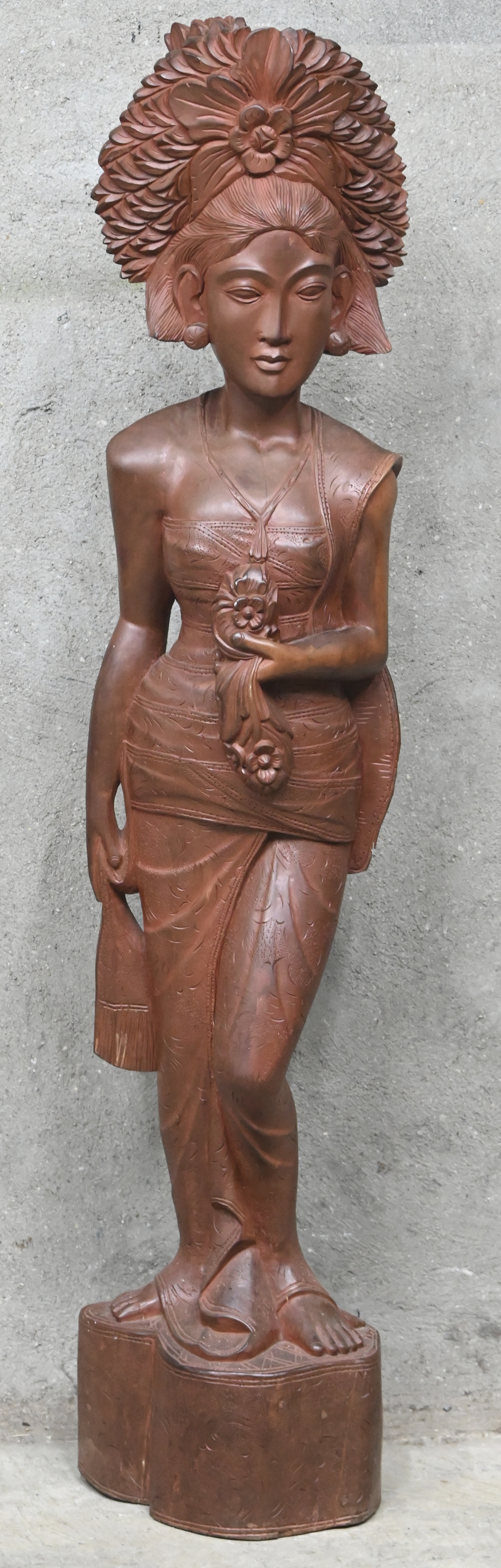 Een gesculpteerd houten beeld van een Indonesische dame Een gesculpteerd houten beeld van een Indonesische dame.