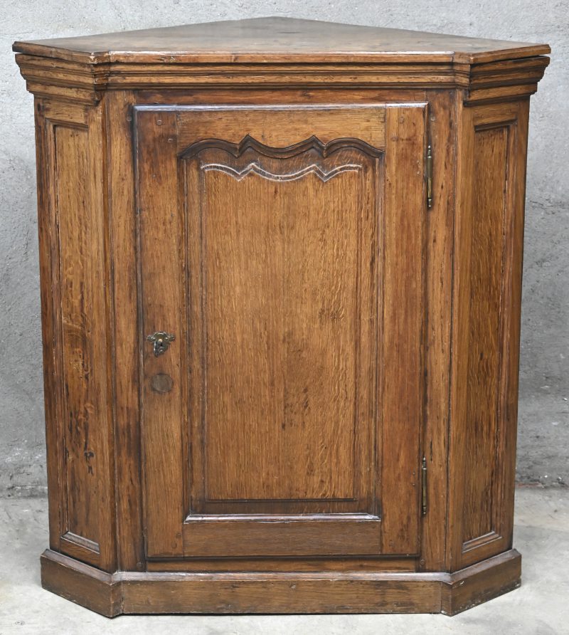 Een massief eikenhouten hoekkast met 1 deur.