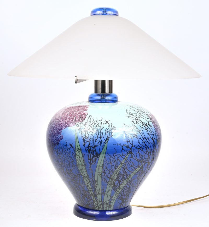Een blauw porseleinen, vintage Italiaanse tafellamp met glazen kap. Versierd met planten decor en onderaan gemerkt.