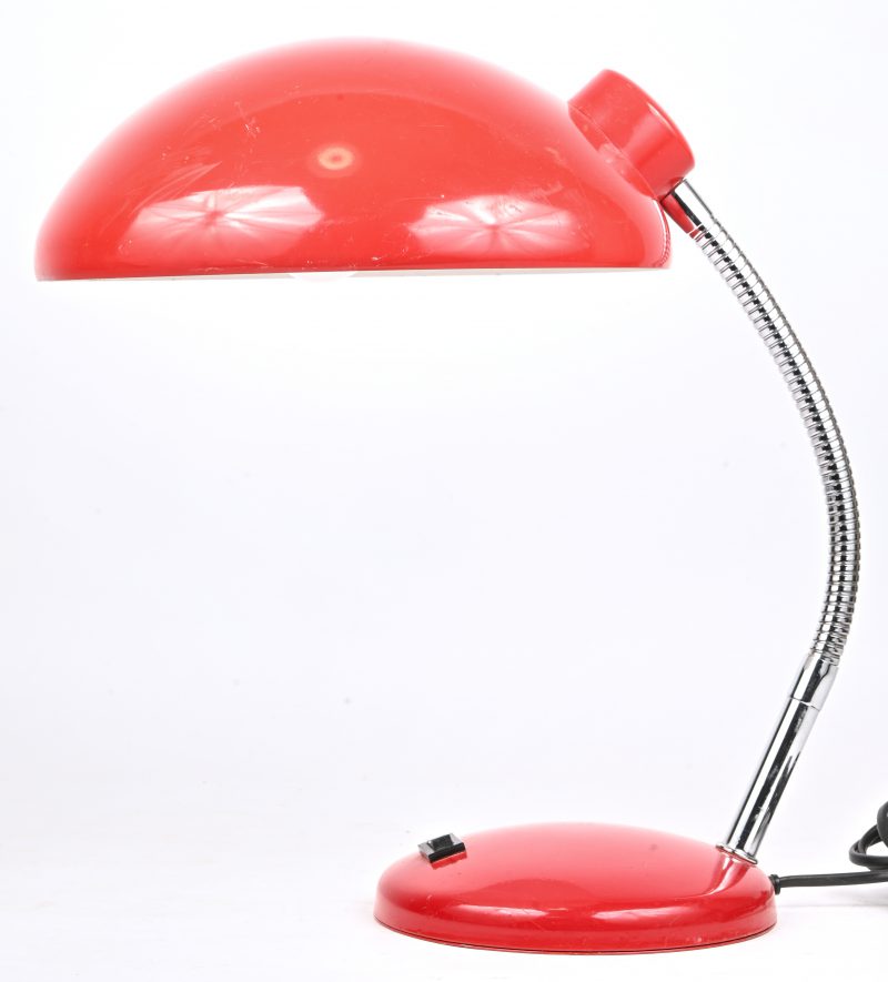 Een vintage bureaulamp, rood en chromé metaal.