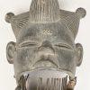 Een gesculpteerd houten masker, Ogoni, Nigeria, met beweegbare mond en metalen tanden.