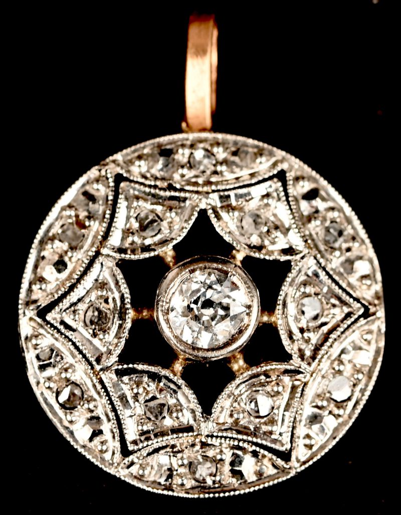 Een 18 kt wit- en geelgouden hanger bezet met diamanten oude slijp met een gezamenlijk gewicht van +- 0,30 ct.