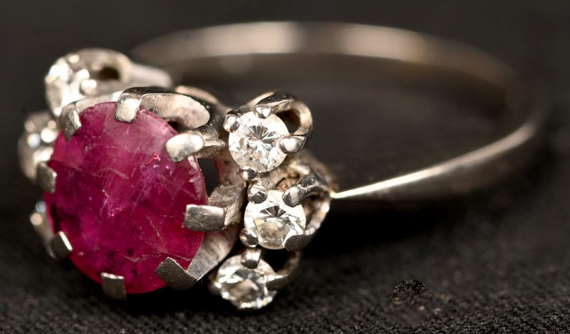 Een 18 kt witgouden ring bezet een centrale ruwe robijn van +- 1,50 ct. en met diamanten met een gezamenlijk gewicht van +- 0,30 ct.