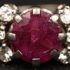Een 18 kt witgouden ring bezet een centrale ruwe robijn van +- 1,50 ct. en met diamanten met een gezamenlijk gewicht van +- 0,30 ct.