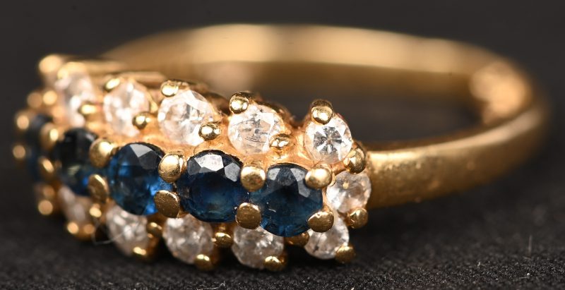Een 18 kt geelgouden ring bezet met saffieren met een gezamenlijk gewicht van +- 0,40 ct. en met diamanten met een gezamenlijk gewicht van +- 0,30 ct.