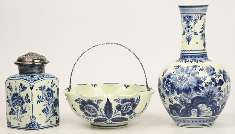 Een lot Delfts blauw aardewerk bestaande uit een kalebas vaas, een schaaltje met handvat en een theebus gemerkt RAM.