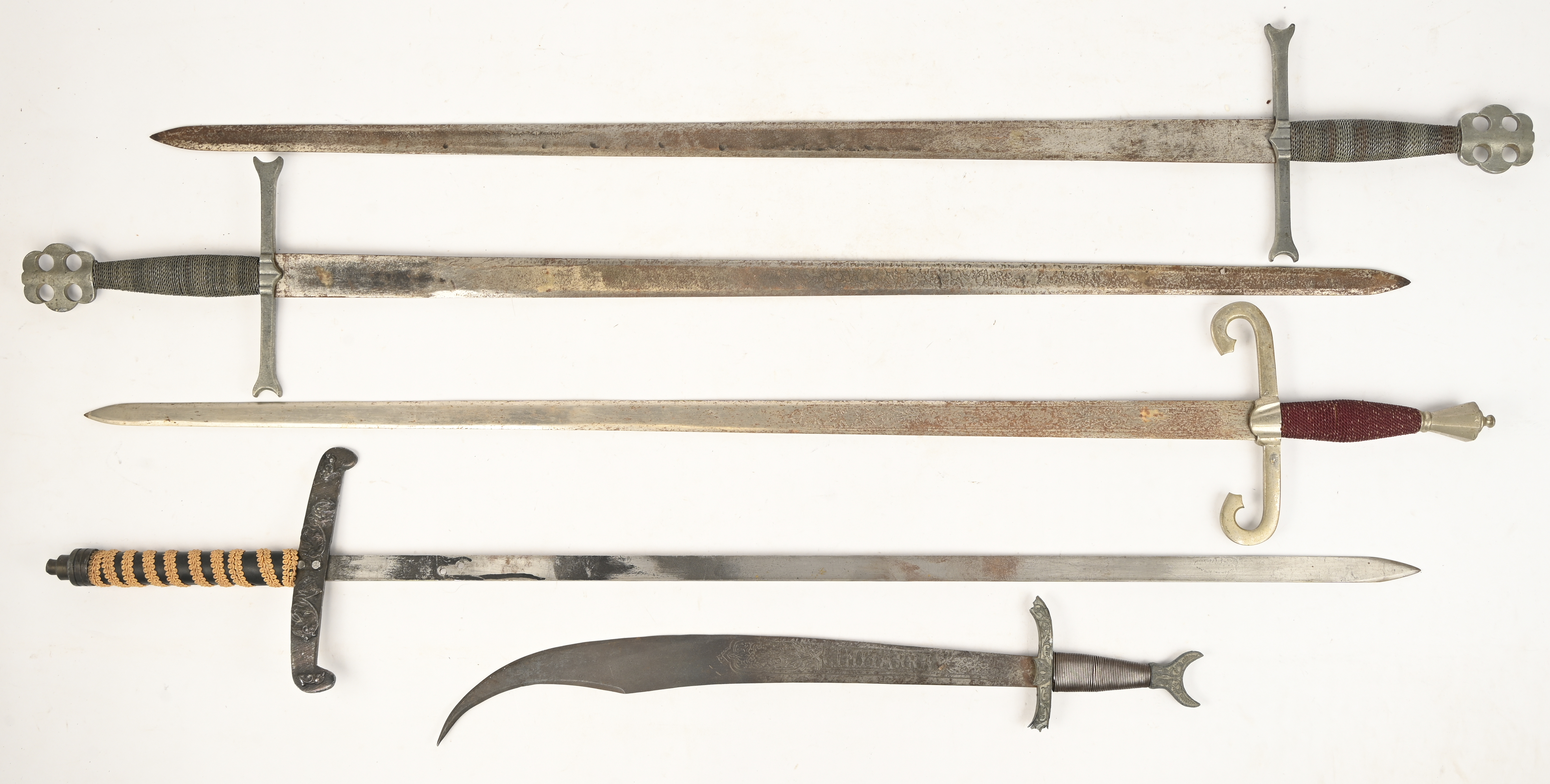 Een lot van 4 replica middeleeuwse ridder zwaarden. Enkele gemerkt “made in Spain”, sporen van oxidatie. Bijgevoegd scimitar gemerkt “Cimitarra”, met breuksporen aan het handvat Een lot van 4 replica middeleeuwse ridder zwaarden. Enkele gemerkt “made in Spain”, sporen van oxidatie. Bijgevoegd scimitar gemerkt “Cimitarra”, met breuksporen aan het handvat.
