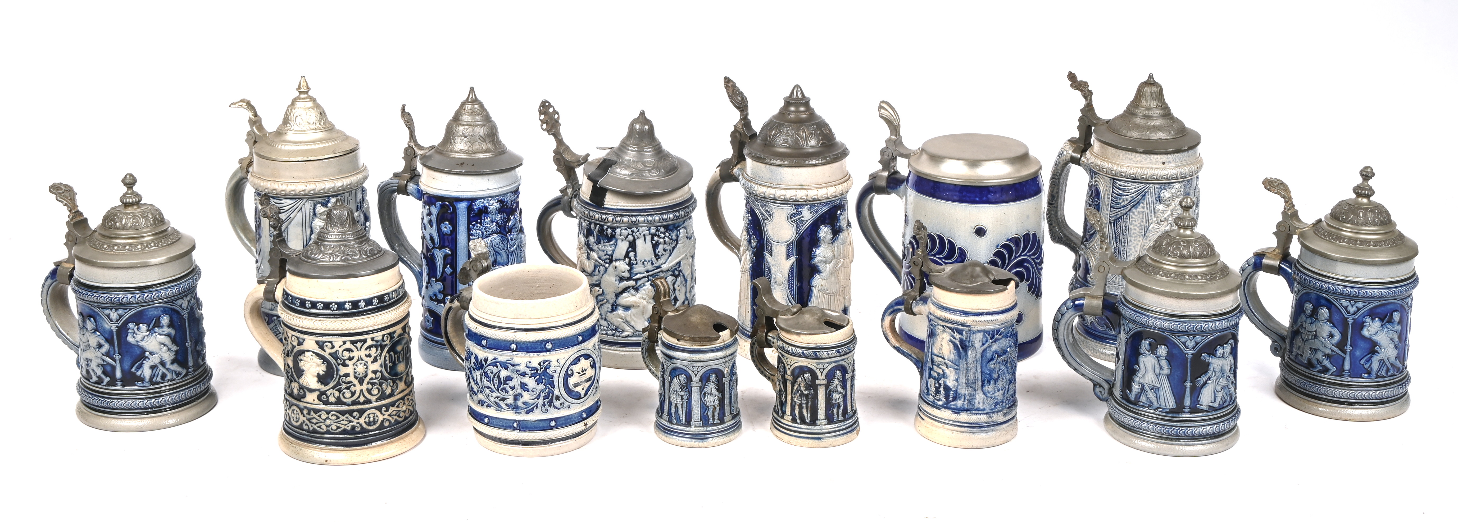 Een lot van 14 Westerwald bierpullen, verschillende formaten. Enkele stukken hebben schade aan het deksel en één deksel is manco Een lot van 14 Westerwald bierpullen, verschillende formaten. Enkele stukken hebben schade aan het deksel en één deksel is manco.