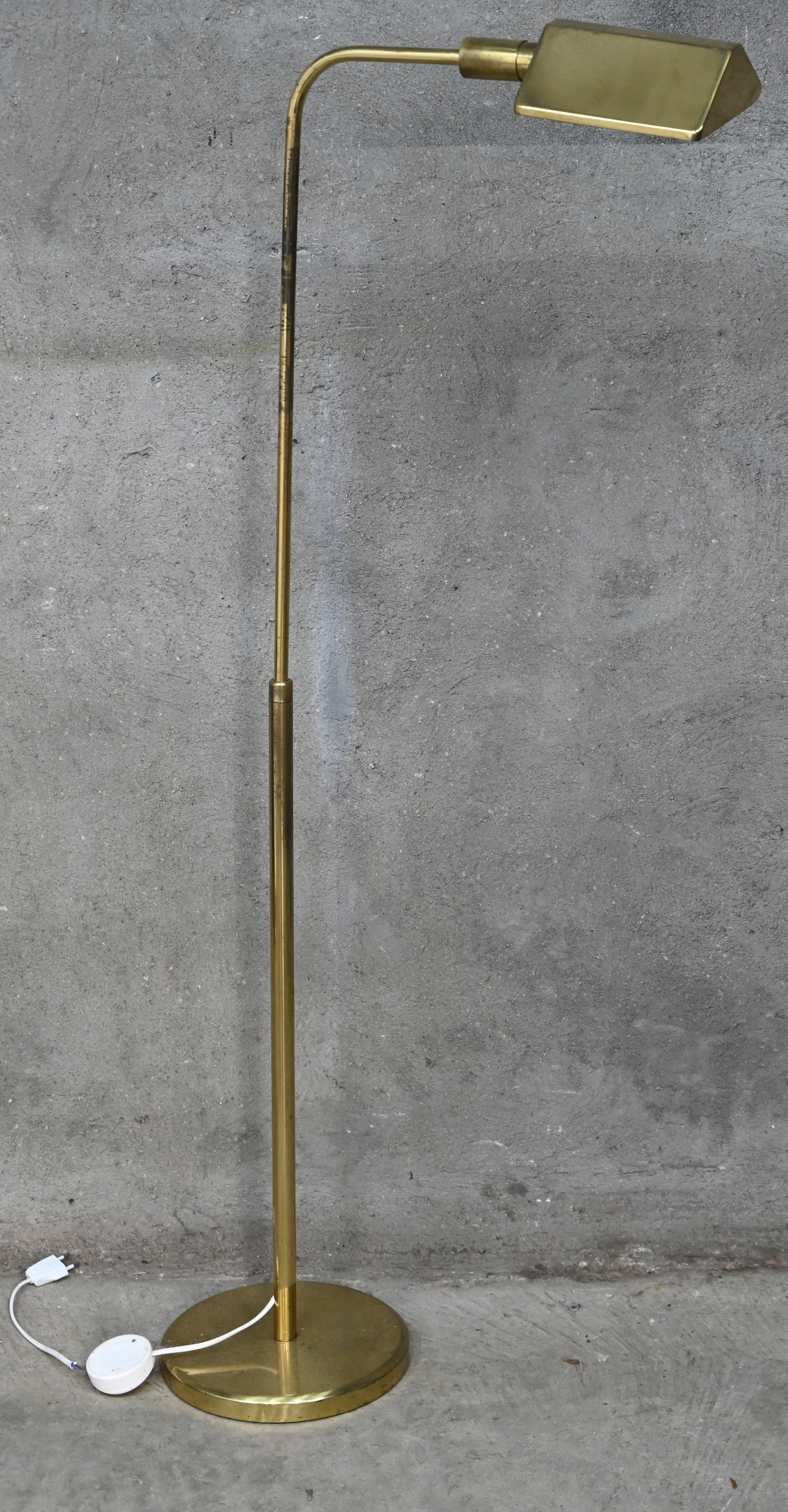 Een goudkleurige staande lamp, in hoogte verstelbaar Een goudkleurige staande lamp, in hoogte verstelbaar.