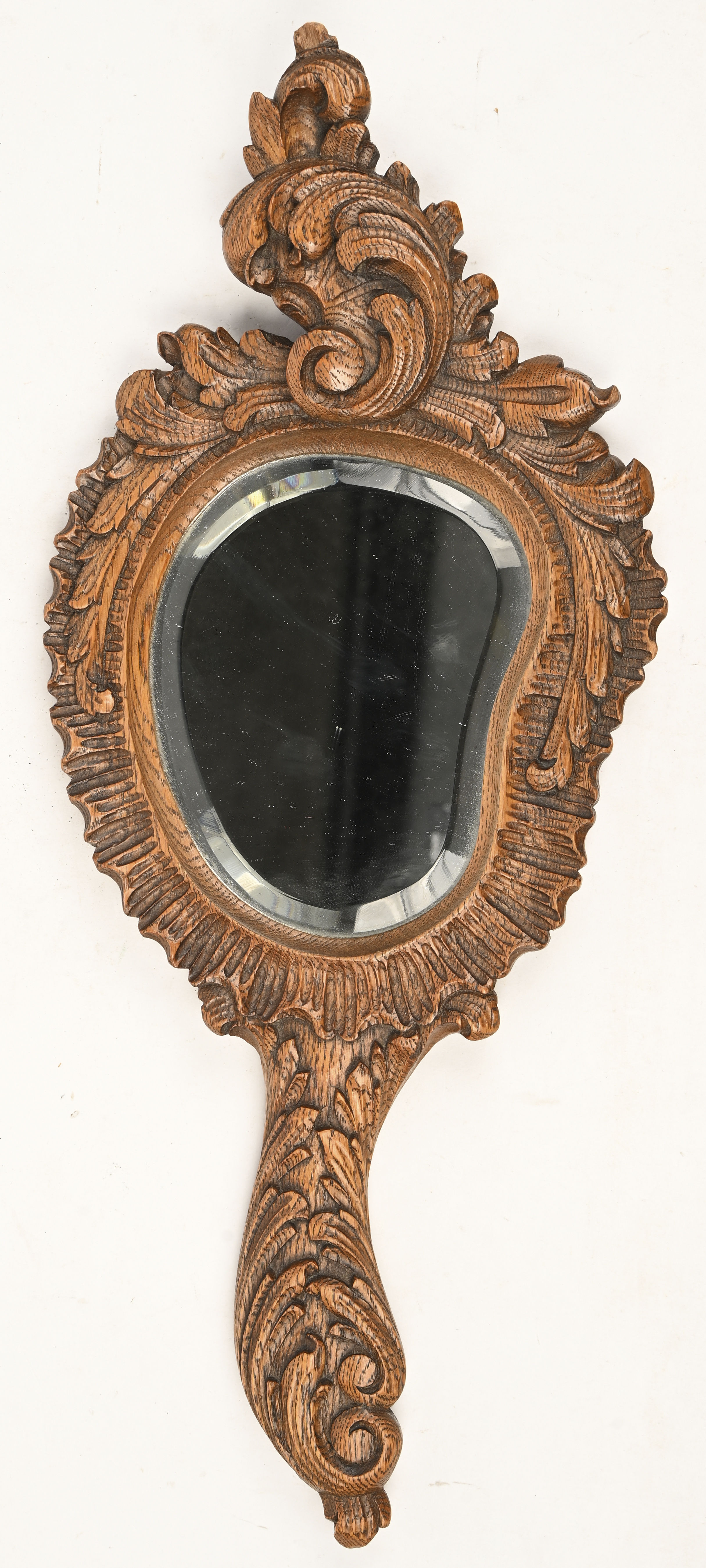 Een antiek geslepen handspiegeltje in massief houten gesculpteerde kader Een antiek geslepen handspiegeltje in massief houten gesculpteerde kader.