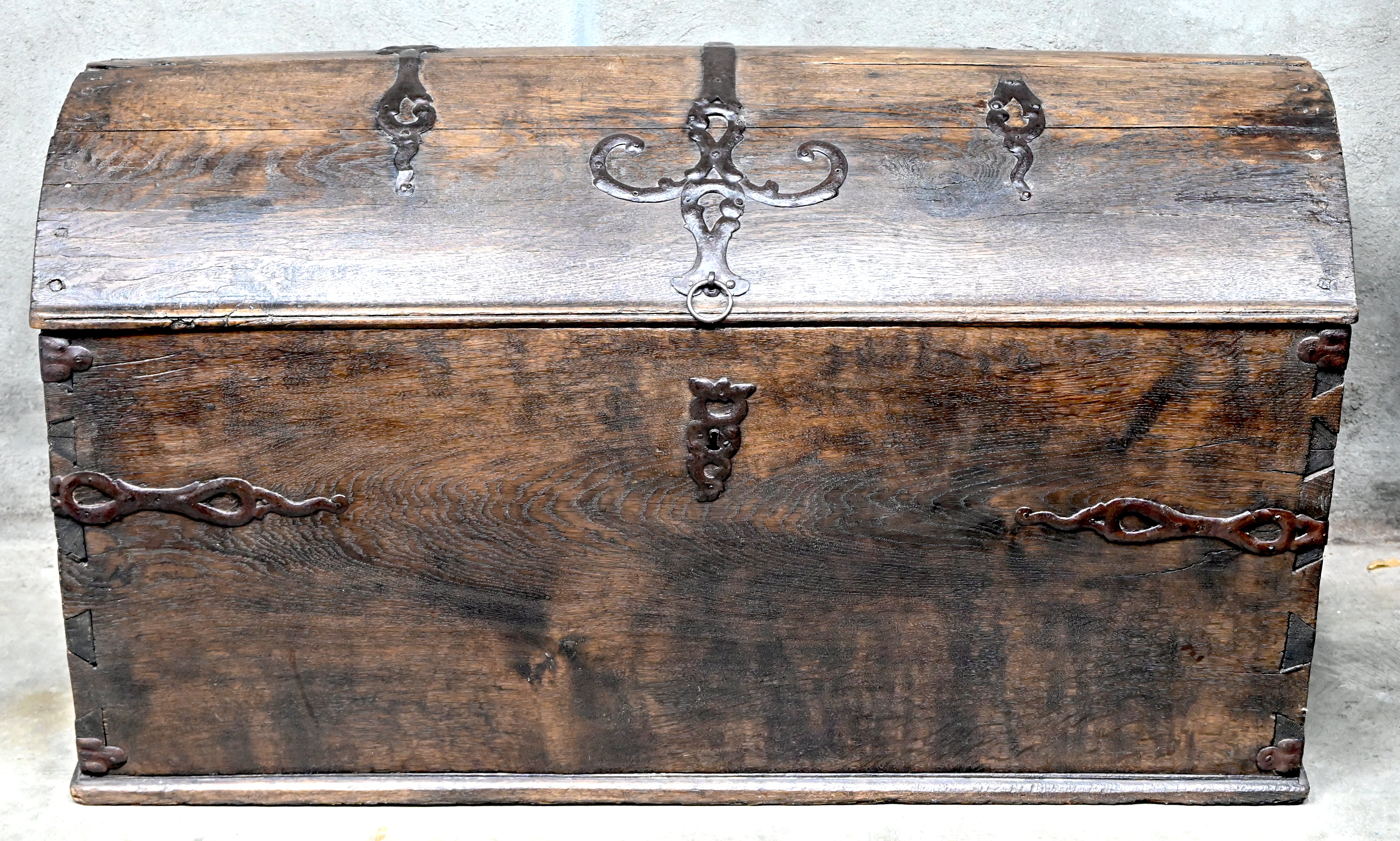 Een grote eikenhouten koffer met een gegalbeerd deksel en smeedijzeren beslag. XIXe eeuw Een grote eikenhouten koffer met een gegalbeerd deksel en smeedijzeren beslag. XIXe eeuw.