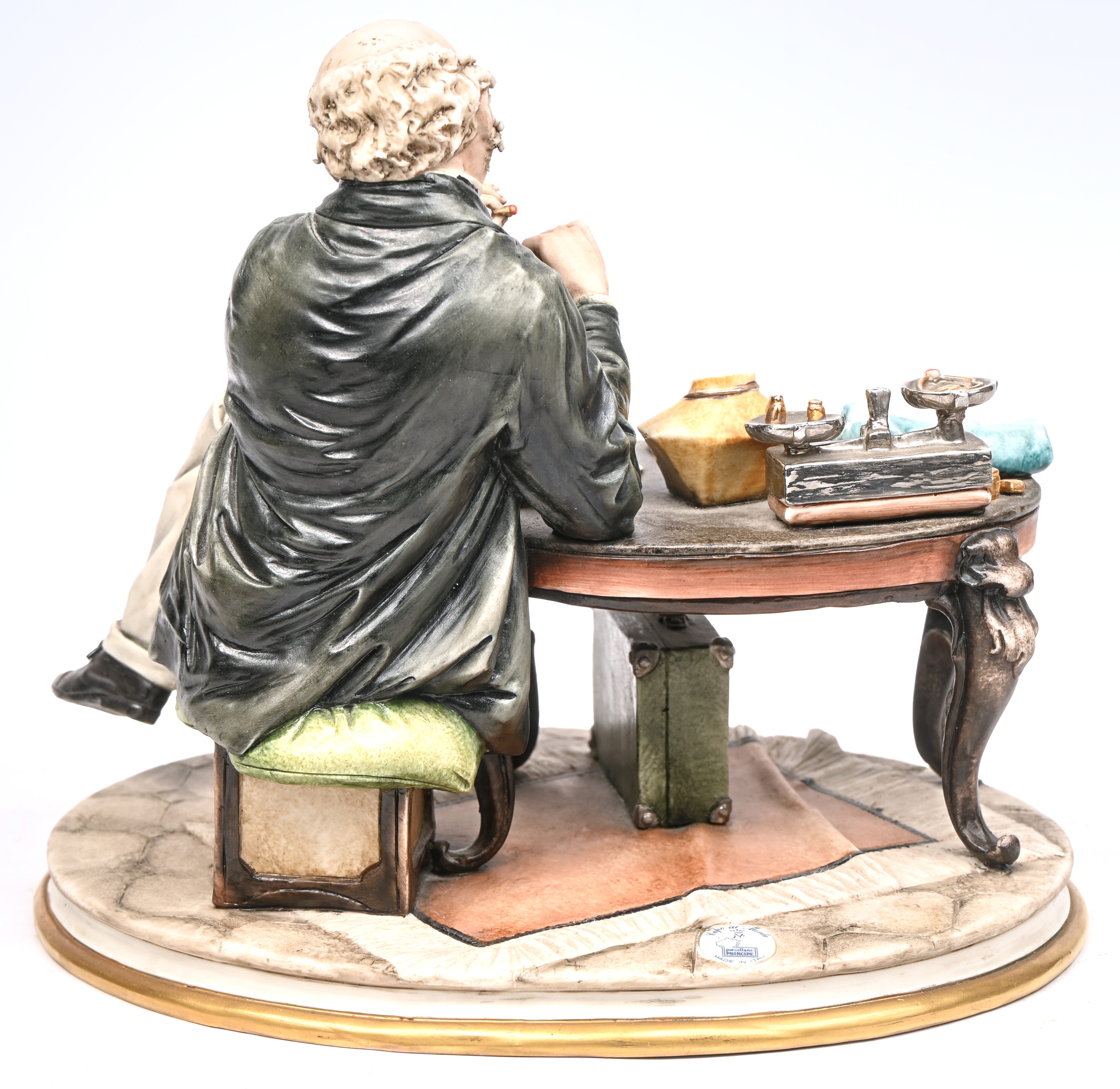 “De Juwelier”. Beeldje van polychroom biscuit. Gemerkt en gesigneerd. Eén vinger ontbreekt “De Juwelier”. Beeldje van polychroom biscuit. Gemerkt en gesigneerd. Eén vinger ontbreekt.