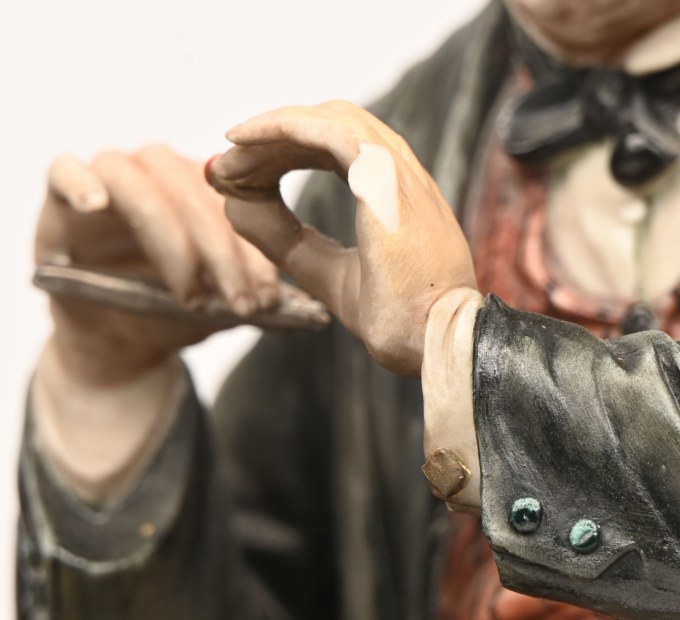 “De Juwelier”. Beeldje van polychroom biscuit. Gemerkt en gesigneerd. Eén vinger ontbreekt “De Juwelier”. Beeldje van polychroom biscuit. Gemerkt en gesigneerd. Eén vinger ontbreekt.