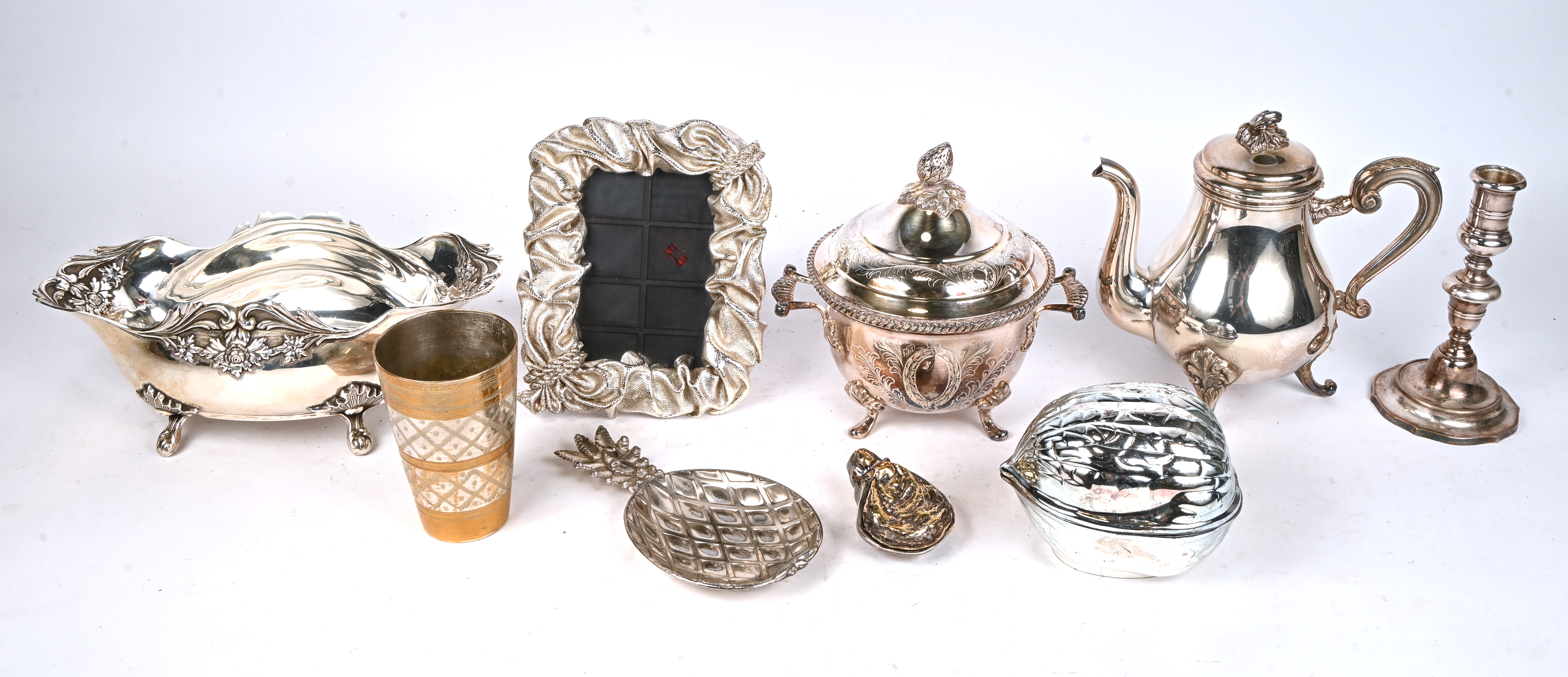 Een lot verzilverde voorwerpen. Een fruitschaal en een theepot gemerkt Claridge, een terrine met deksel, een bekertje, een notenschaal, een fotolijst, een schaaltje, een oestervormig doosje en een kandelaar Een lot verzilverde voorwerpen. Een fruitschaal en een theepot gemerkt Claridge, een terrine met deksel, een bekertje, een notenschaal, een fotolijst, een schaaltje, een oestervormig doosje en een kandelaar.