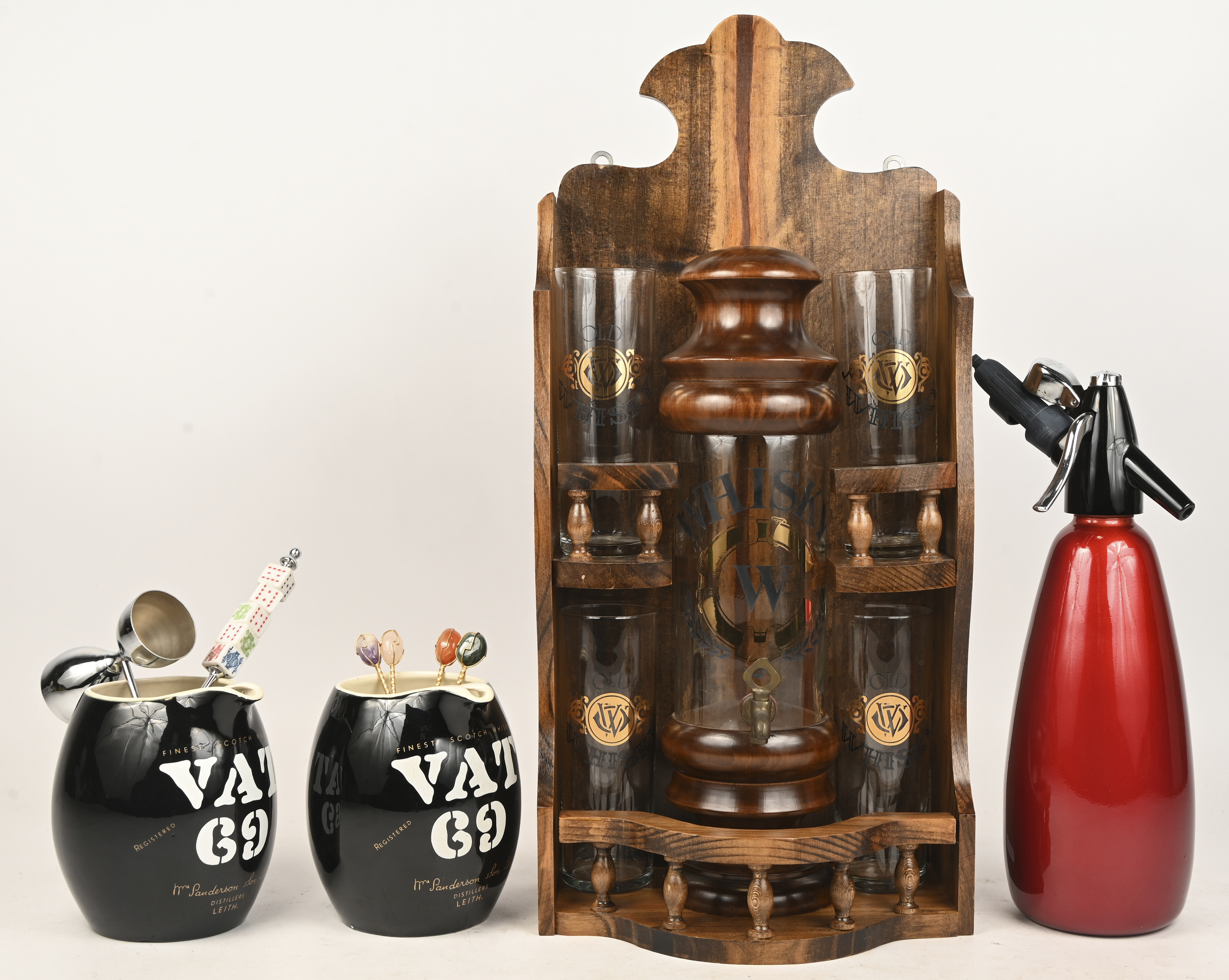 Een houten rekje met vier whiskyglazen en een whiskyfonteintje met houten deksel. We voegen er aan toe: een syphon, een paar aardewerken waterkannetjes van VAT69 en enkele lepeltjs e.d., sommige versierd met pokerstenen Een houten rekje met vier whiskyglazen en een whiskyfonteintje met houten deksel. We voegen er aan toe: een syphon, een paar aardewerken waterkannetjes van VAT69 en enkele lepeltjs e.d., sommige versierd met pokerstenen.