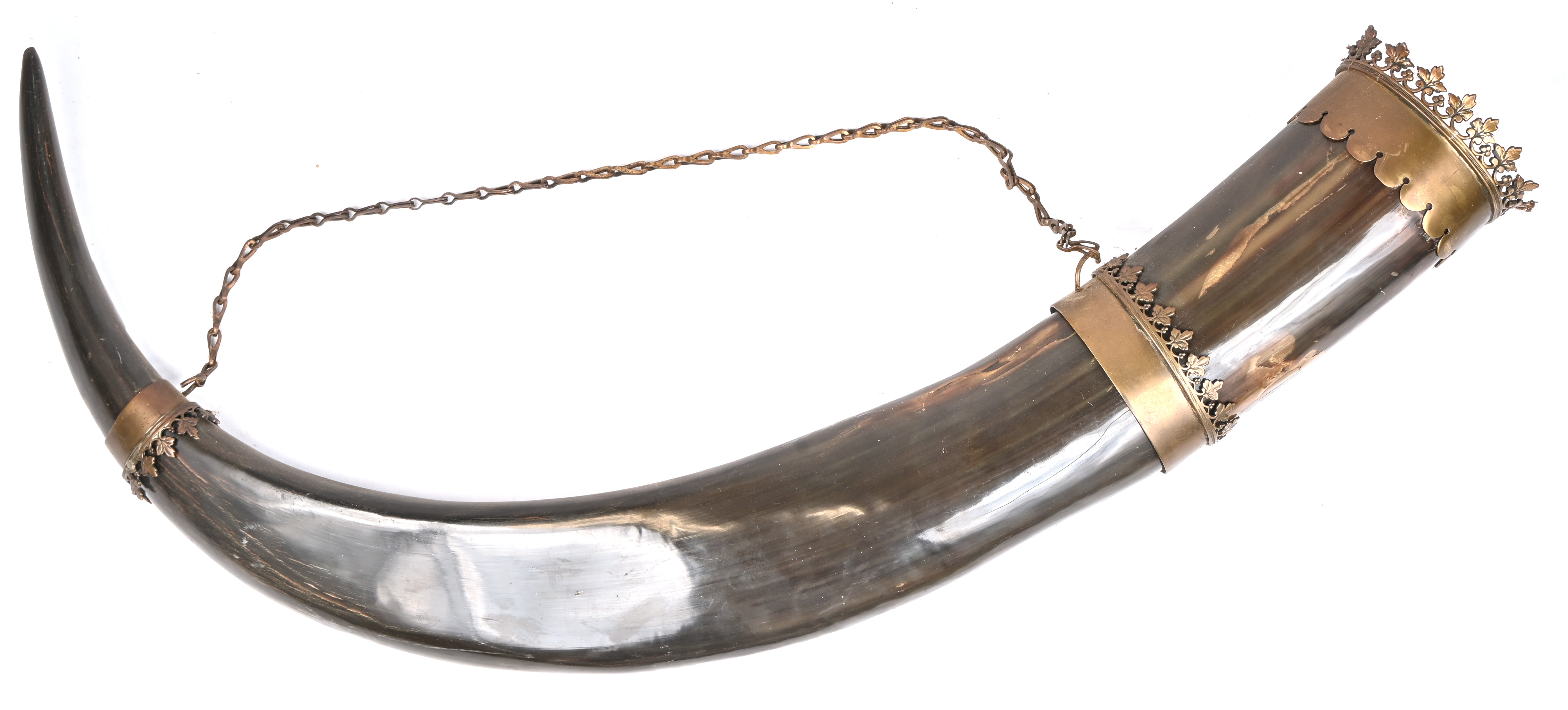 Een grote runderhoorn met messingen monturen versierd met een bladfries Een grote runderhoorn met messingen monturen versierd met een bladfries.