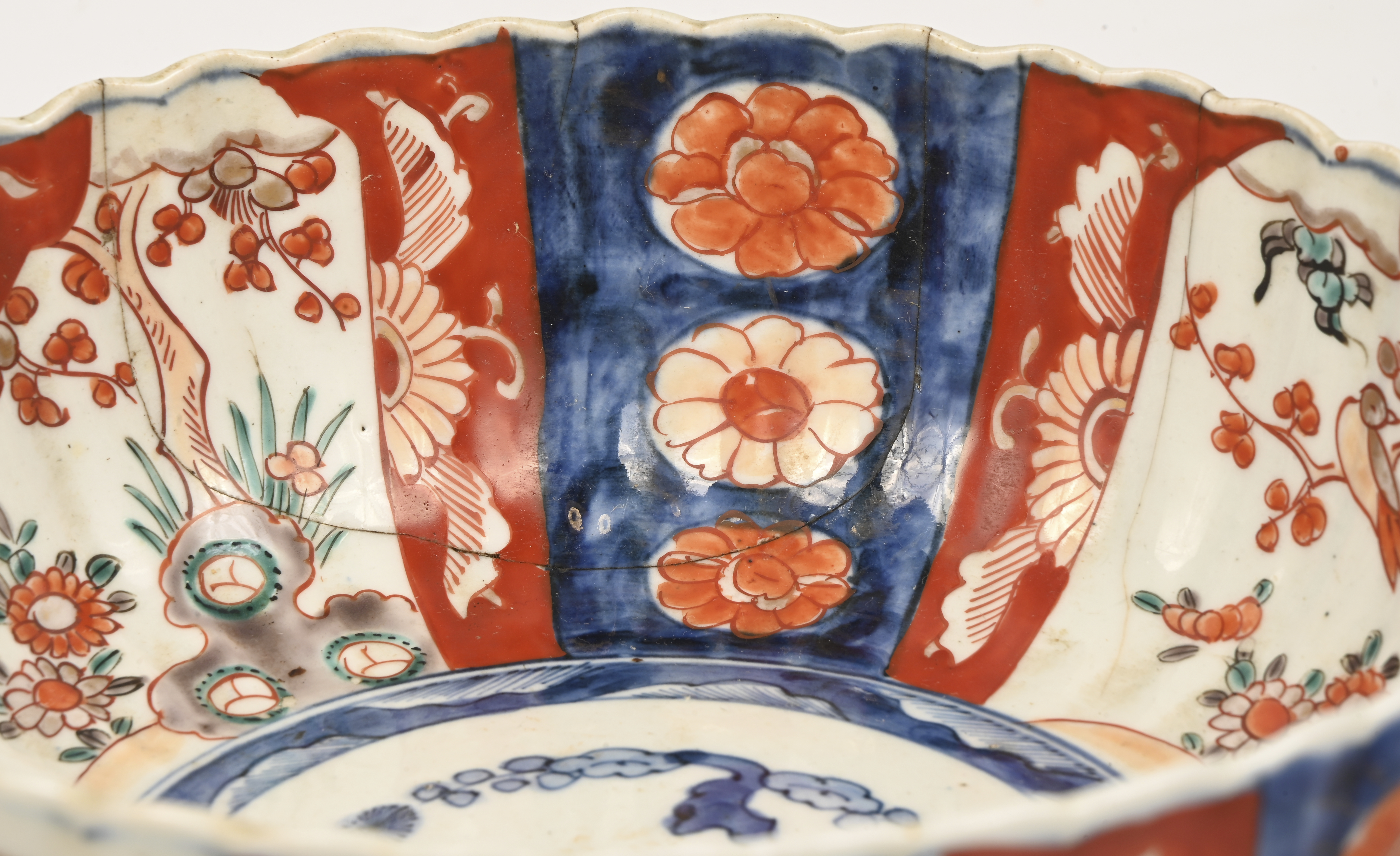 Een grote schotel (30 cm, gebarsten), een coupe (gebarsten) en een klein vaasje van Imari porselein. Eerste helft XXste eeuw Een grote schotel (30 cm, gebarsten), een coupe (gebarsten) en een klein vaasje van Imari porselein. Eerste helft XXste eeuw.