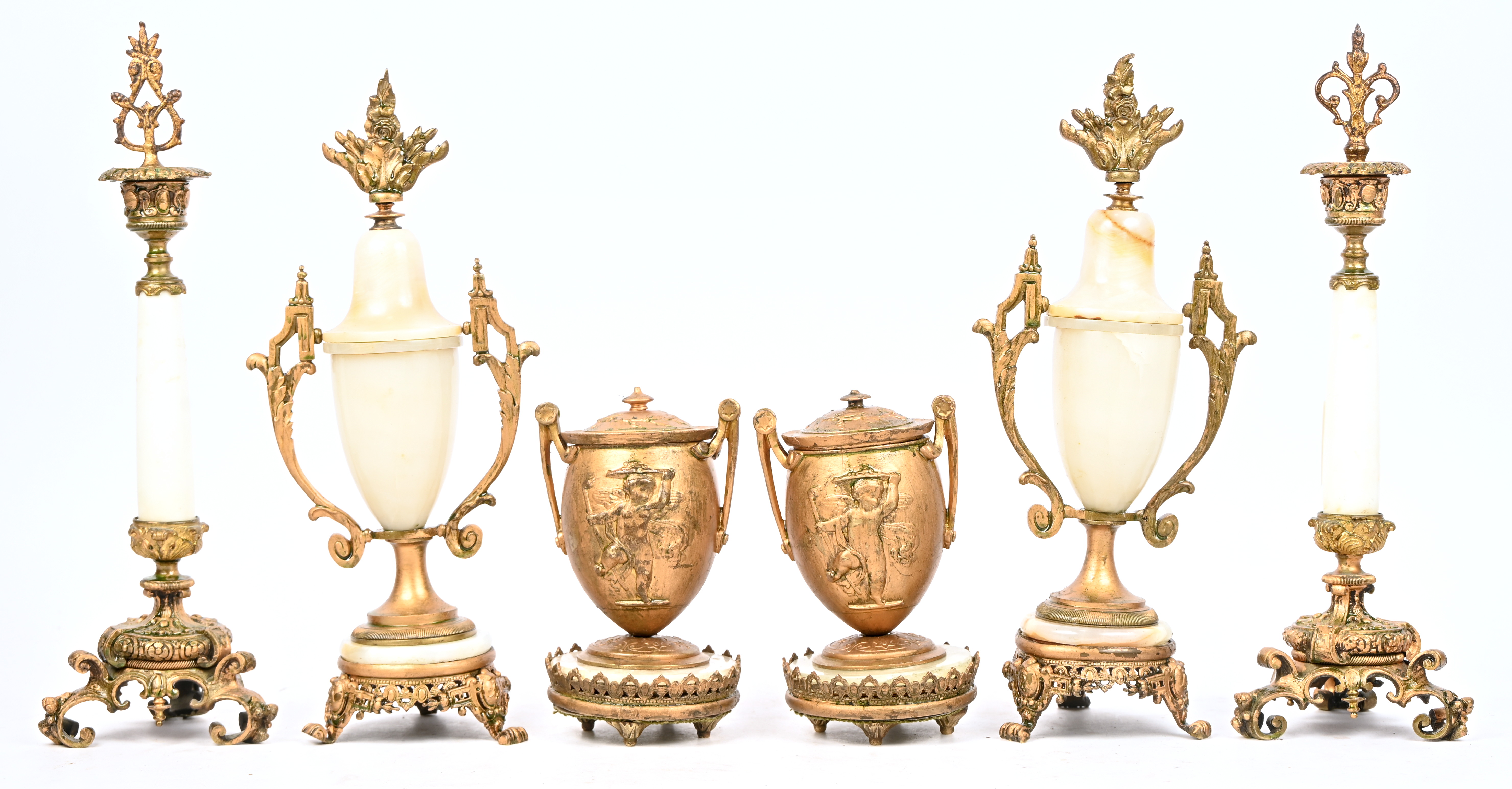 Een bureaugarnituur van goudkleurig metaal en onyx. Bestaande uit een inkstel versierd met een Napoleonbeeldje, een paar penhouders, een paar kandelaars, een paar cassolettes, een brievenhouder, een briefopener, een schemerlamp, een fotolijst. Directoire stijl, medio XXste eeuw Een bureaugarnituur van goudkleurig metaal en onyx. Bestaande uit een inkstel versierd met een Napoleonbeeldje, een paar penhouders, een paar kandelaars, een paar cassolettes, een brievenhouder, een briefopener, een schemerlamp, een fotolijst. Directoire stijl, medio XXste eeuw.