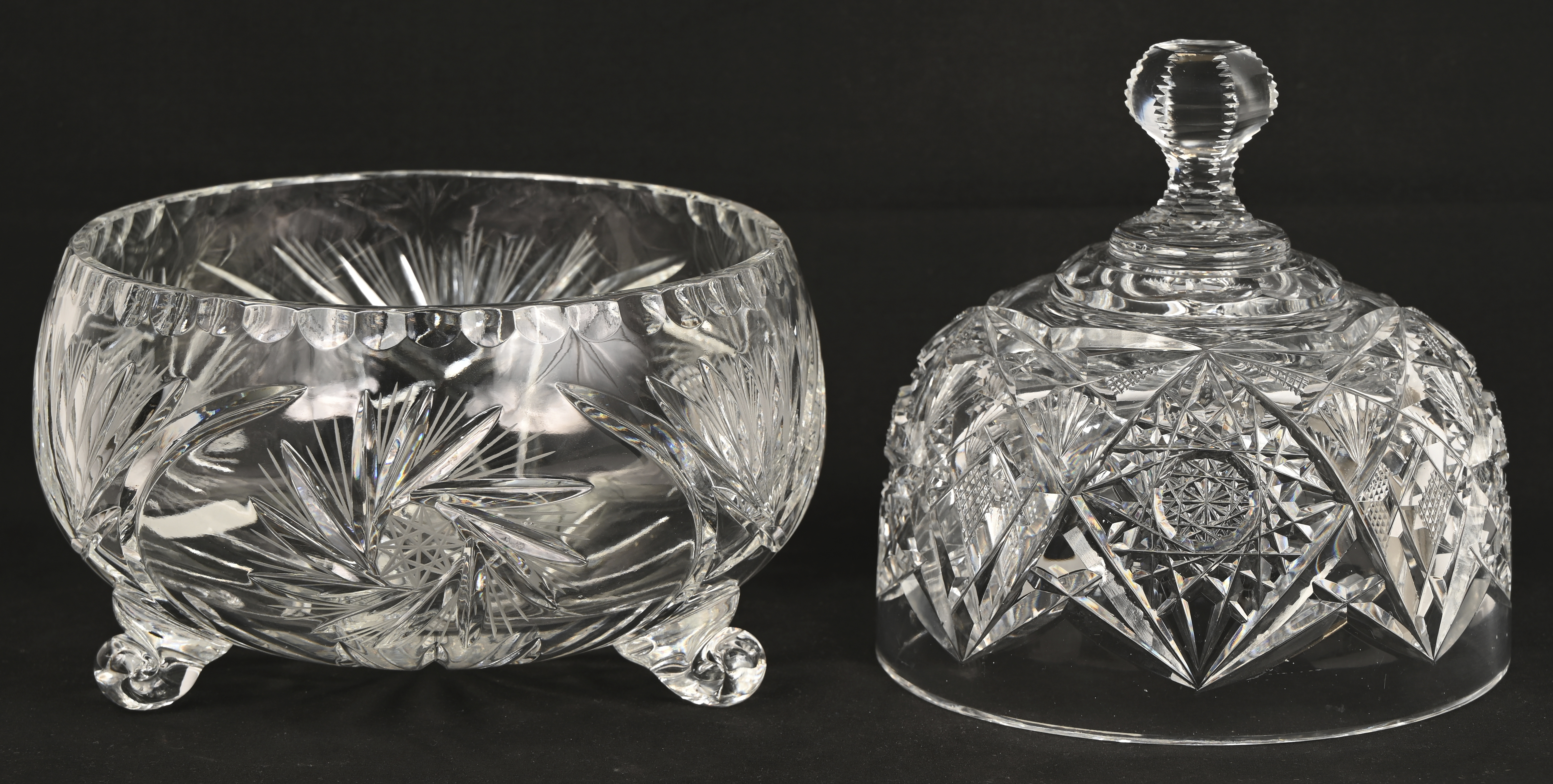 Een gevarieerd lot kleurloos en gekleurd kristal bestaande uit een bonbonniere, twee stolpen waarvan één met voet en een coupe Een gevarieerd lot kleurloos en gekleurd kristal bestaande uit een bonbonniere, twee stolpen waarvan één met voet en een coupe.