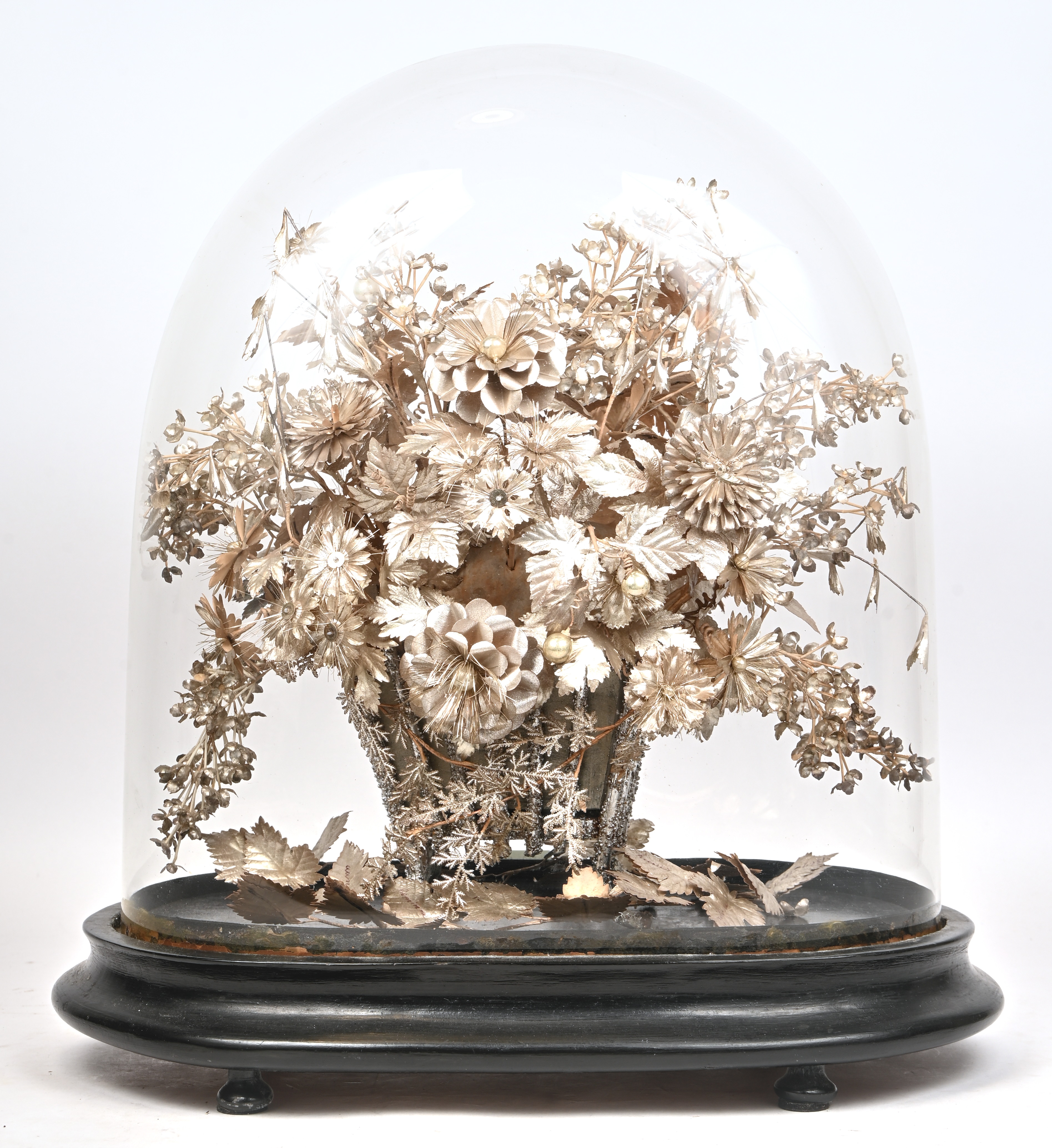 Een grote stolp met een zilverkleurige bloemenmand Een grote stolp met een zilverkleurige bloemenmand.